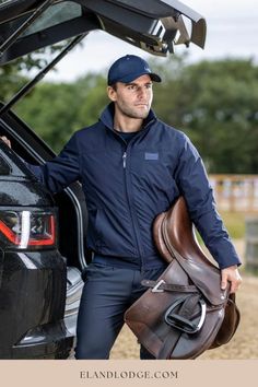 a man is standing next to the trunk of a car with his luggage in it