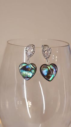 Abalone  hearts with teardrop CZ accented silver ear posts. Approximately 1.5 inches long. Silver Dangle Heart Earrings For Party, Elegant Teardrop Earrings With Heart Charm, Silver Dangle Heart Earrings, Pearl Drop Dangle Heart Earrings For Anniversary, Silver Dangle Heart Earrings With Pearl Drop, Silver Heart Earrings With Pearl Drop, Teardrop Heart Earrings In Sterling Silver, Teardrop Heart Earrings For Gift, Silver Heart Earrings With Pearl Drop For Gift