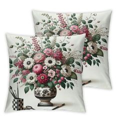 two pillows with flowers on them sitting next to pens and pencils in a vase