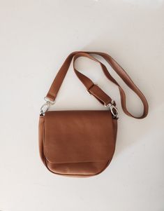 This minimalist chic handbag offers a comfortable yet stylish solution for everyday use. It has a simple, clean-cut design that perfectly suits an active lifestyle. With its spacious main compartment, this bag works both as a casual bag and an office bag. Crafted by expert Bali artisans using split cow leather. It can easily fit all the essentials - keys, phone, wallet, lip balm. It features a zip closure and flap, along with an adjustable strap from 21'' - 45". Dimensions: Approximately 7 1/2"H Office Bag, Minimalist Chic, Chic Handbags, Active Lifestyle, Cut Design, Casual Bags, Cow Leather, Adjustable Straps, The Balm