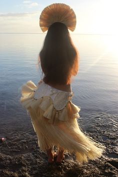 the back of a woman's head as she stands in shallow water