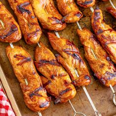 chicken skewers are lined up on a tray