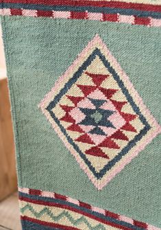 a blue and red rug sitting on top of a wooden floor