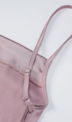 The features of this garment are reflected in the fabric and back design. The fabric is made from light silk, which is comfortable to the touch, breathable and sweat-absorbent, making it comfortable to wear while also highlighting high-end luxury. The back is designed with a silk waistband with cut-outs and a bow, which reveals a superior boned shape and highlights the slender, powerful appeal of the woman. The bow tie design at the waist adds style to the skirt, adding a more stylised flavour w Pink Fitted Slip Dress With Delicate Straps, Pink Slip Dress With Delicate Straps For Spring, Chic Pink Slip Dress With Adjustable Straps, Chic Pink Slip Dress With Tie Back, Summer Pink Slip Dress With Delicate Straps, Pink Sleeveless Satin Finish Dress, Pink Camisole Dress With Adjustable Straps, Pink Silk Feminine Slip Dress, Feminine Pink Slip Dress With Adjustable Straps