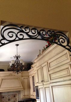 a kitchen with white cabinets and a chandelier hanging from the ceiling above it