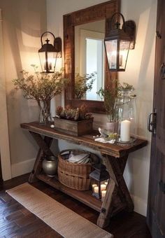 a wooden table topped with vases filled with flowers and candles next to a mirror