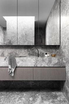 a bathroom with marble counter tops and grey walls, along with large mirrors on the wall