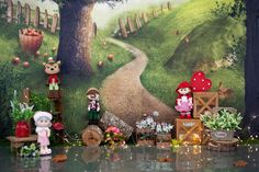 there are many stuffed animals on display in front of a wall with flowers and trees