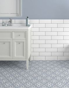 a bathroom with blue and white tile on the floor