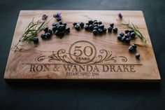 a cutting board with blueberries on it and the words 50 years written in black