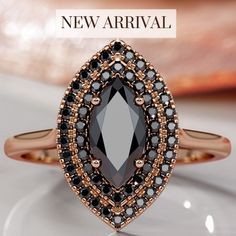 a black and white diamond ring sitting on top of a glass plate with the words new arrival