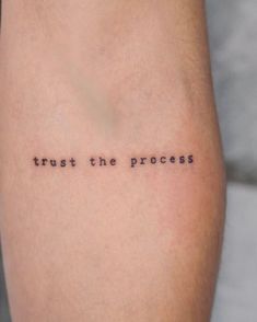 a tattoo saying trust the process on someone's leg