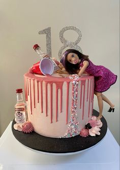 a birthday cake with a barbie doll on top and pink icing dripping down the side