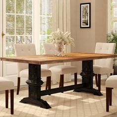 a dining room table with white chairs in front of it and an area rug on the floor