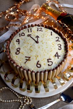 a cake with white frosting and gold sprinkles sitting on a table