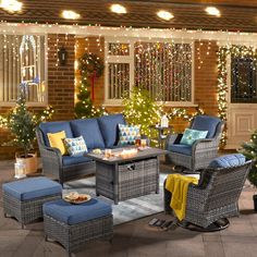 an outdoor living room decorated for christmas with blue furniture and lights on the windowsill