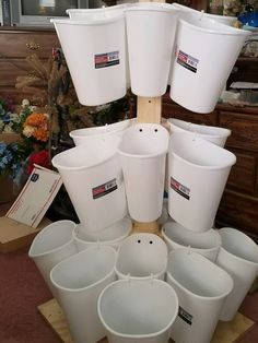 several white buckets are stacked on top of each other in order to be used