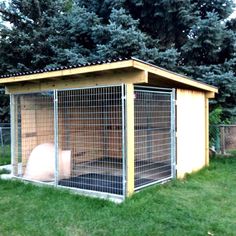 a dog kennel in the middle of some grass