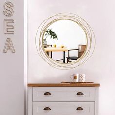 a white dresser with a mirror above it and a table in the corner next to it