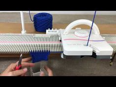 a person is working on a machine with yarn and scissors in front of it,