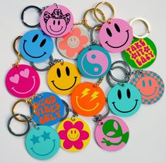 a bunch of smiley face key chains on a white surface