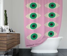 a pink shower curtain with green eyes on it