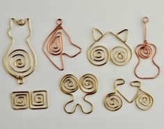 several different types of earrings and pendants on a white surface with one being cut out