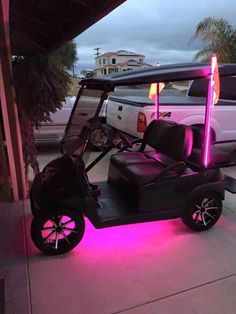 a golf cart that is lit up with purple lights on the front and back seats