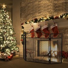 a decorated christmas tree in front of a fireplace