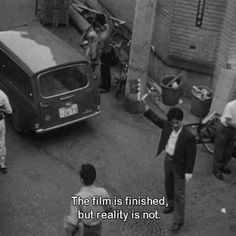 an old black and white photo shows people walking down the street with their arms in the air