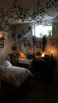 a bedroom with plants hanging from the ceiling and candles lit on the bed in front of it