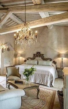 an elegant bedroom with chandelier, bed and couch in the middle of it