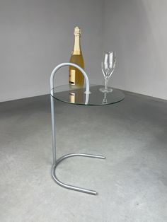 a glass table with a wine bottle and two glasses sitting on top of the table