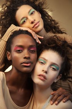 three models pose for the camera with their arms around each other's shoulders and eyes closed