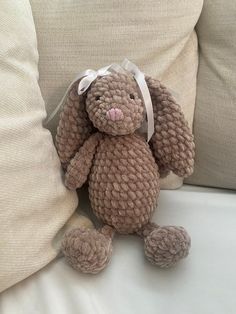 a stuffed animal sitting on top of a bed next to pillows