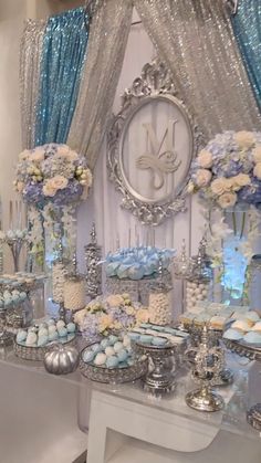 a table topped with lots of blue and white desserts