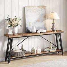 a wooden table with two vases on it and a painting in the corner next to it