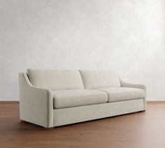 a white couch sitting on top of a wooden floor