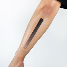 a person's arm with a cross tattoo on the left side of their arm