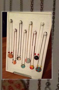 a white box with many different necklaces hanging from it's front and back sides