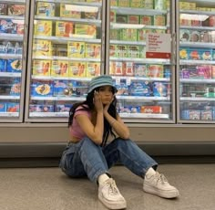 a woman sitting on the ground in front of a store