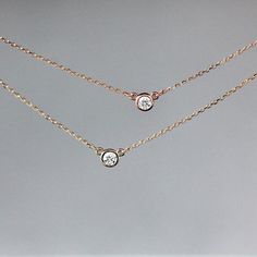 • .167 carats (3.5mm) diamond, SI2, G-H, 100% conflict free• 14k yellow gold or rose gold• 18 inch chain A gorgeous, round brilliant diamond is set entirely in 14k gold and hung in the center of a 14k gold chain in this solitaire necklace. You can choose between 14k yellow gold and 14k rose gold. The diamond is .167 carats (1/6 carat), SI2, G-H in color, and 100% ethical and conflict free. The diamond pendant measures 4.6mm across and the total length of the necklace is 18 inches. This necklace Delicate Diamond Necklace, Floating Diamond Necklace, Floating Necklace, Solitaire Necklace, Diamond Solitaire Necklace, Solitaire Necklaces, Layering Necklace, Diamond Pendant Necklace, Circle Earrings