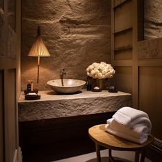 a bathroom with stone walls and a bowl sink