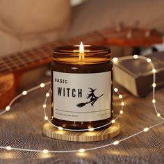 a candle sitting on top of a table next to a string of lights and a guitar