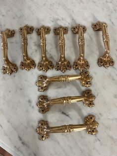 six antique brass drawer pulls on a marble table