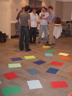 a group of people standing in a room with colorful tiles on the floor and walls