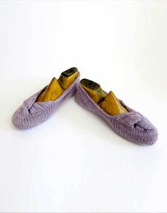 two pairs of purple slippers sitting on top of a white floor next to each other