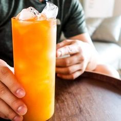 a man sitting at a table with a drink in his hand