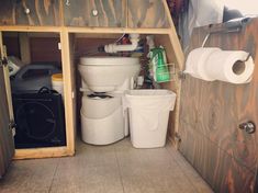 two white buckets are sitting next to each other in a small room with wood paneling