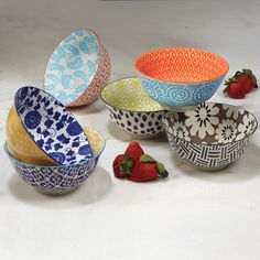 several bowls with designs and strawberries on the side